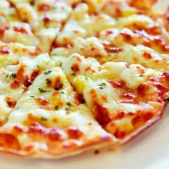 Pyszna pizza z tortilli na patelni, z ciągnącym się serem i ziołami. Idealna na szybki obiad.