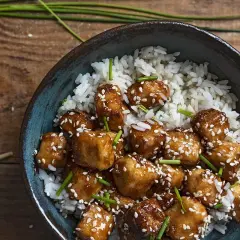 Pyszny stir fry z tofu, podany z ryżem i posypany sezamem. Idealny posiłek dla wegan.