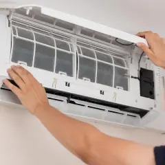 Man opens air conditioner to clean filters. Dirty filters can cause why the air conditioner freezes.