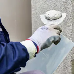 Pracownik nakłada tynk silikonowy. Sprawdź aktualną cenę za m2 robocizny i ciesz się nową elewacją.