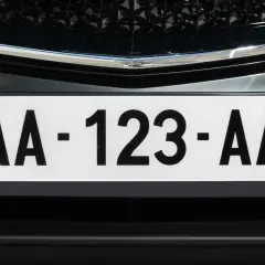 Plaque immatriculation noire avec le code "AA-123-AA" et le logo de l'Auvergne-Rhône-Alpes.