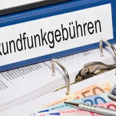 Ordner mit "Rundfunkgebühren" beschriftet. Geld und Taschenrechner liegen daneben. Antrag auf **gez befreiung wohngeld** möglich.