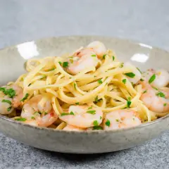 En skål med linguine och scampi, perfekt för ett snabbt scampi recept. Garnerad med färsk persilja.