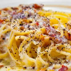 Spaghetti alla carbonara tradizionali, un piatto cremoso con guanciale croccante e abbondante pepe nero.