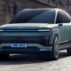 Przyszłościowy Hyundai Ioniq 9 w kolorze miętowym, poruszający się po miejskiej ulicy.