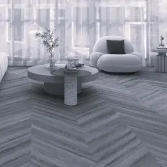 Nowoczesny salon z sofą i fotelem, a podłogę zdobi elegancka jodełka francuska.