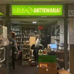 W antykwariacie "Książka Dla Każdego" panuje atmosfera cmentarz zapomnianych książek. Wnętrze pełne regałów z literaturą, gdzie ludzie przeglądają stare tomy.