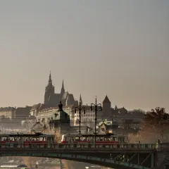 Most w Czechach z tramwajami na tle zamku.