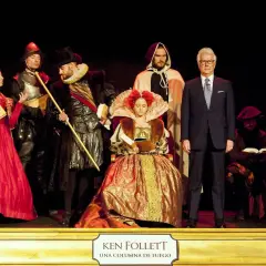 Schauspieler in historischen Kostümen und ein Mann im Anzug stehen auf einer Bühne. Sie repräsentieren die "Kinder der Freiheit" in einer Inszenierung.
