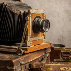 Antyczny aparat mieszkowy na kufrach. Zastanawiasz się, w którym roku wynaleziono aparat fotograficzny?