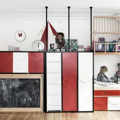 Zwei Kinder teilen sich ein kreatives Zimmer mit Hochbetten und Tafel.