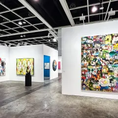 A vibrant collage artwork dominates the wall at Art Basel, showcasing a diverse collection of images.