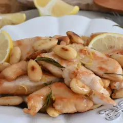 Succulento pollo al limone con mandorle tostate e rosmarino, guarnito con spicchi di limone fresco.