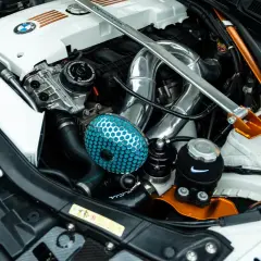 Motor tuning en un BMW: filtro de aire azul, intercooler cromado y refuerzo naranja.