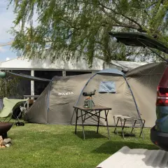 Dacia camper gotowe na przygodę. Namiot, krzesła i ognisko czekają na rozpalenie.