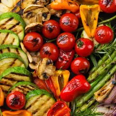 Un assortiment coloré de légumes grillés, parfait en accompagnement barbecue : courgettes, tomates cerises, poivrons, asperges, champignons, aubergines et oignons rouges.