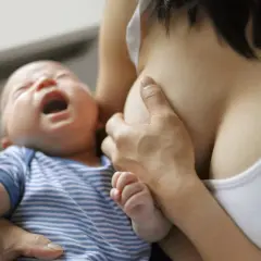 Bébé pleure pendant l'allaitement, possible signe de mastite infectieuse.