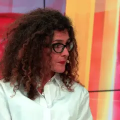 Aleksandra Pawlicka, z burzą kręconych włosów i okularami, opowiada o swoich dzieciach na tle kolorowego studia.