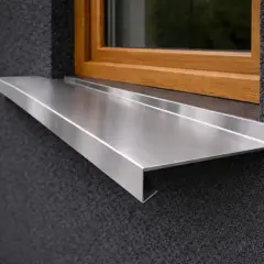 Nowoczesne parapety zewnętrzne stalowe, elegancko komponujące się z ciemną elewacją i drewnianą ramą okna.