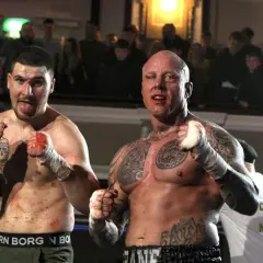 Två blodiga kämpar redo för bare knuckle boxing Sverige. Publiken hejar på i bakgrunden.