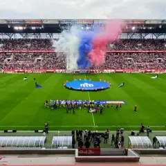 Oprawa meczu Górnik Zabrze – Cracovia: dym w barwach klubowych, zawodnicy na murawie i pełne trybuny.