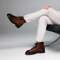 Scarponcini stringati in pelle marrone lucida, un classico per un look **oxs uomo** elegante e avventuroso.