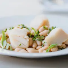 Deliciosa ensalada de bacalao con tiernos garbanzos y hierbas frescas, un plato ligero y sabroso.