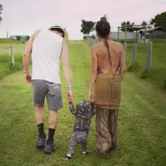 Ian Somerhalder z rodziną, spacerują po trawie. Rodzice trzymają za ręce swoje **ian somerhalder dzieci**, które stawiają pierwsze kroki.