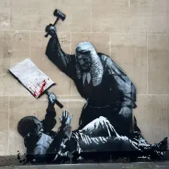 A judge wielding a gavel over a fallen figure, a signature piece by Banksy, questioning justice.