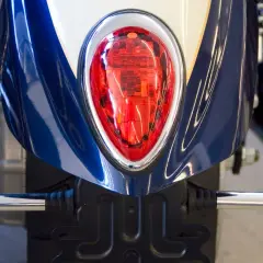 Detalle de moto azul con luces LED naranjas y piloto trasero rojo. Podría ser una multa por llevar luces LED en moto.