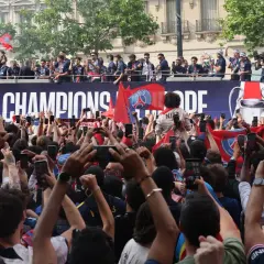 Foule en liesse à Paris, le 14 juillet, pour célébrer les champions sur un bus à impériale. Les téléphones sont levés pour immortaliser l'instant.