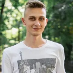 Uśmiechnięty nastolatek w białej koszulce z grafiką Nowego Jorku. Może to być przykład, jak zespół Aspergera objawy u nastolatków mogą być subtelne.