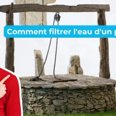 Un homme souriant pointe vers un puits ancien, suggérant des solutions pour le traitement de l'eau de puits.