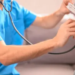 Lekarz osłuchuje klatkę piersiową dziecka, diagnozując zapalenie płuc.
