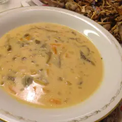 Krämig trattkantarellsoppa, perfekt för ett mysigt trattkantarellsoppa recept. Serveras i en elegant skål med torkad svamp i bakgrunden.