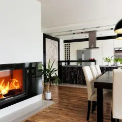 Nowoczesny kominek z płaszczem wodnym, idealny do ogrzania 150m2 domu. Widok na jadalnię i kuchnię.