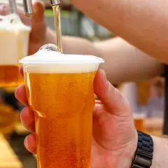 Chmielowy napój w plastikowym kubku, idealny na upalny dzień. Zastanawiasz się, ile kalorii ma piwo bezalkoholowe?