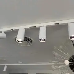 Barra focos techo blanca con focos cilíndricos dirigibles, iluminando un espacio moderno.