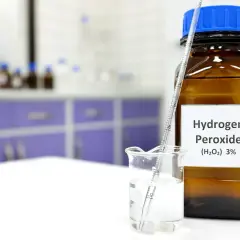 Nadtlenek wodoru zastosowanie w laboratorium: butelka z 3% H₂O₂ i zlewka z cieczą, w której zanurzony jest aerometr.