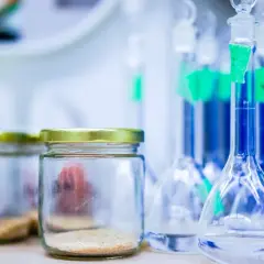 Laboratorium przygotowuje się do analizy. Widać słoiki z próbkami i kolby z płynami, gotowe do wykonania testu na narkotyki z krwi.