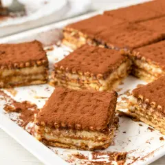 Pyszne, tanie ciasto bez pieczenia z herbatnikami, posypane kakao. Idealne na deser.