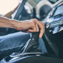 Mano sul cambio, ma il cambio è bloccato, non entrano le marce. Frustrazione alla guida.