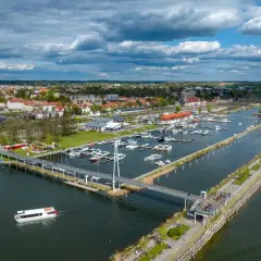 Widok na port jachtowy, miasto i jezioro. To stolica polskiego żeglarstwa, gdzie cumują liczne łodzie i statki.