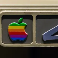 The iconic rainbow Apple logo, a testament to the original apple logo designer's vision, adorns an old computer.