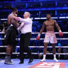 Referee separates boxers after a round. The crowd watches, anticipating how many knockdowns in boxing will occur next.