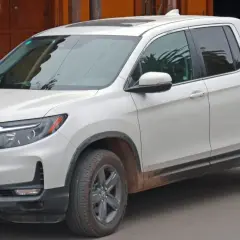 Biały Honda Ridgeline z błotem na progach, gotowy na przygodę.