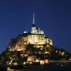 Mont Saint-Michel nocą, jakby z francuskiej baśni. Michał po francusku, czyli Mont Saint-Michel, lśni w ciemnościach.