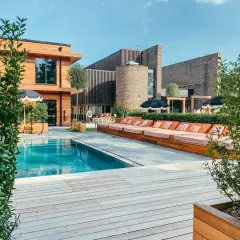 En avkopplande dag vid poolen på Ellery Beach. Solstolar i orange, parasoller och en klarblå pool.