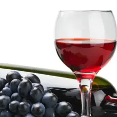 Czerwone wino w kieliszku, butelka i winogrona. Czy wiesz, że resweratrol co to jest, znajduje się w skórce winogron?