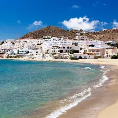 Un pueblo blanco se asoma a una playa dorada y aguas turquesas. Un lugar idílico que ver en Cabo de Gata.